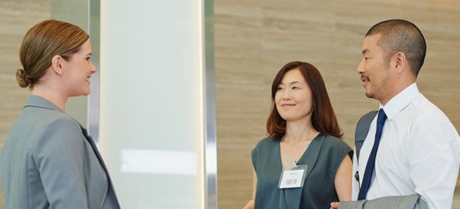 Japanese office workers communicating to a Caucasian illustrating the guide to Japanese translation services in Singapore