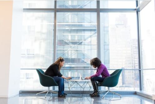 Two female translator siting down facing each other working on their laptop illustrating the vital roles of translator in today globalised world