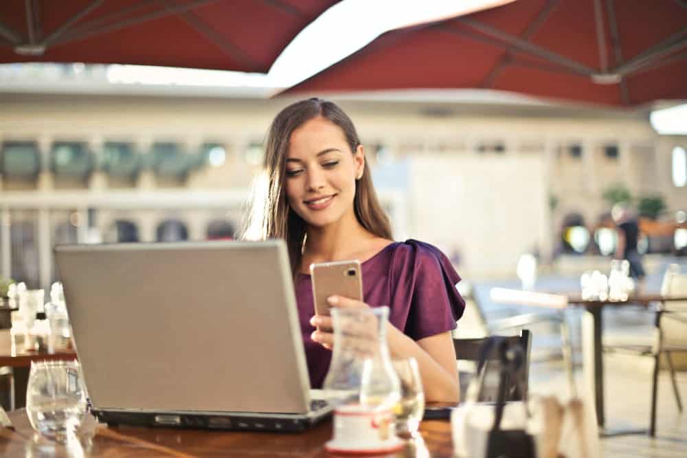 a woman looking at a website in her handphone illustrating guide to website localization for business owners