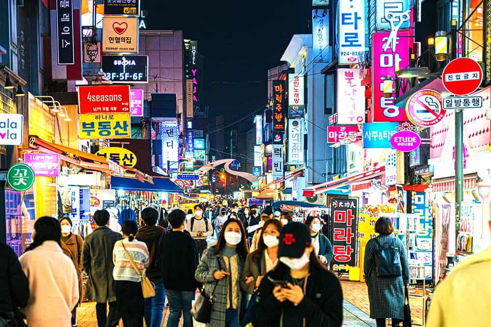 People walking in a busy night street in Korea illustrating the importance of Korean translation services