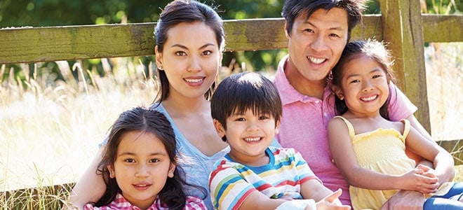 A family of 5 looking into the camera and smiling illustrating birth certificate translation singapore