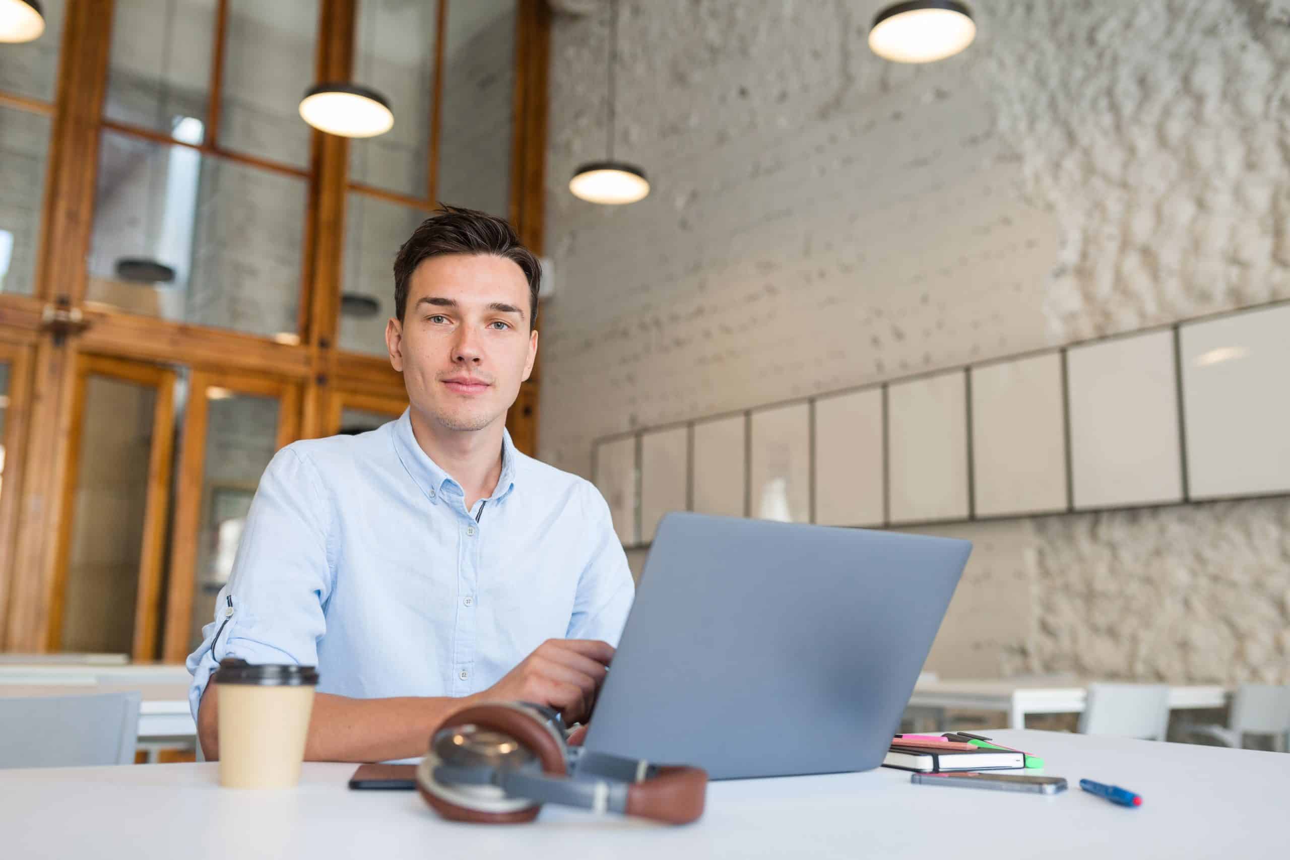 A man working on a transcription project and looking into the camera illustrating importance of audio transcription services