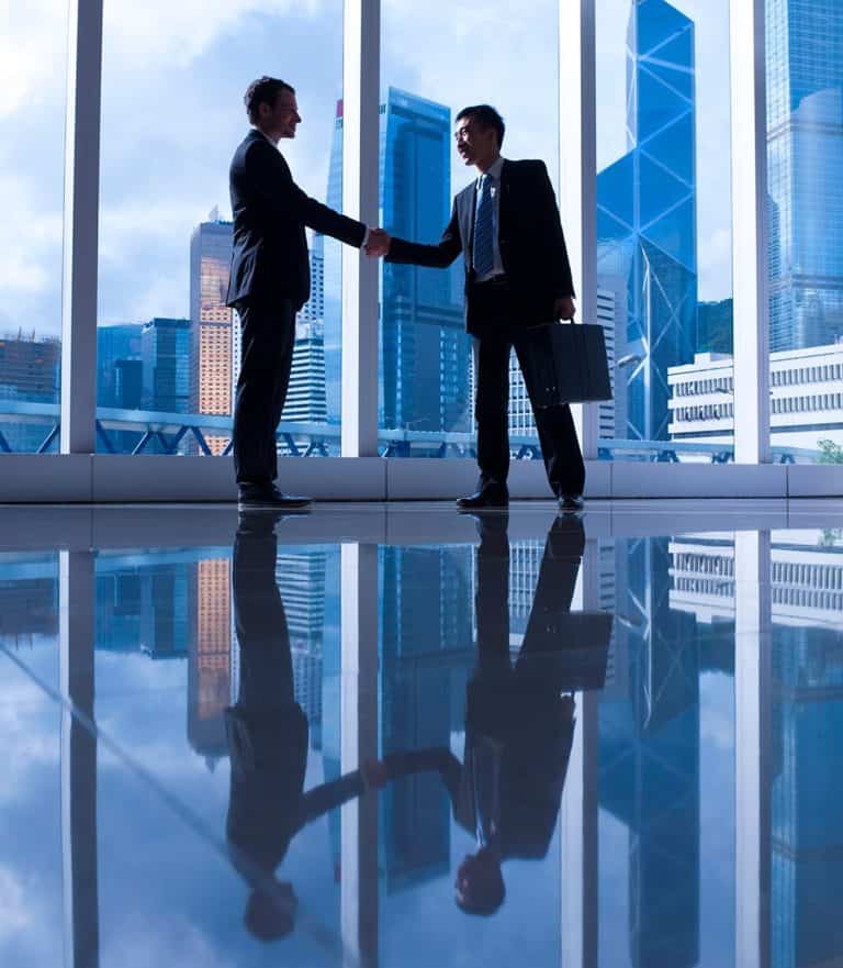 Two men shaking hands illustrating the importance of business translation services