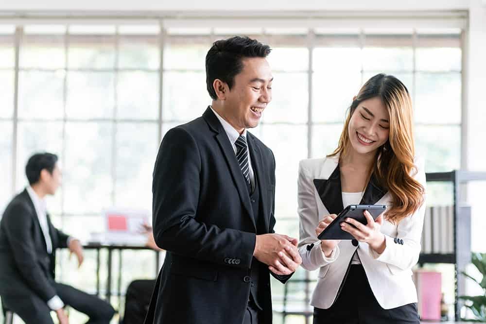 2 office persons discussing in an office illustrating the importance of business translation services