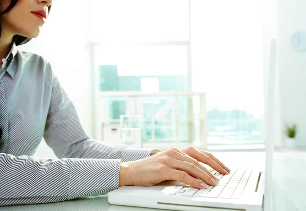 A female copy editor at work and editing on a laptop illustrating the importance of copy editing services