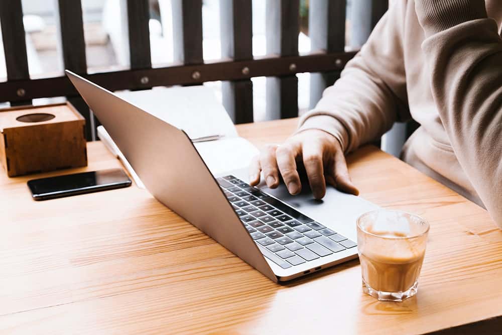 An office worker writing on laptop illustrating the importance of copywriting services