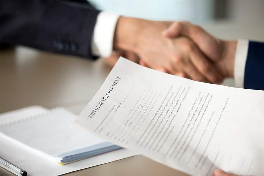 Two male office workers shaking hands illustrating the importance of document translation service