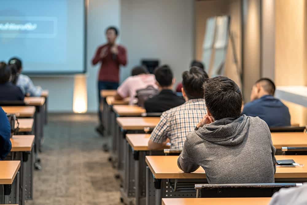 A man teaching in classroom illustrating the importance of education translation services