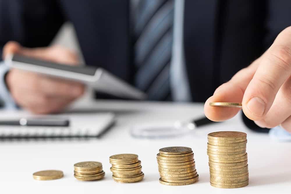 A person tallying money coin to illustrate the importance of financial translation services