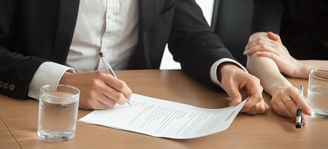 A lawyer signing a legal agreement illustrating professional certified legal translation services