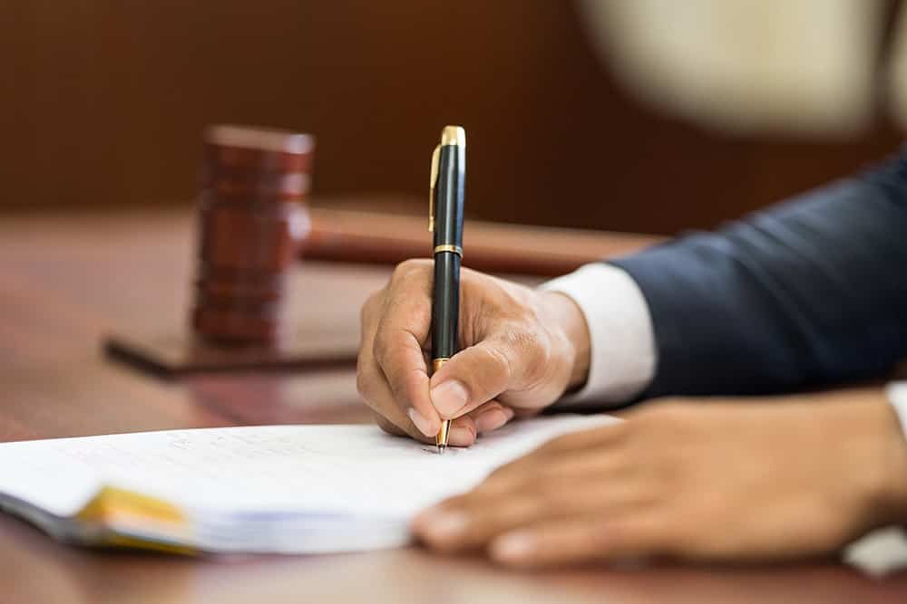 A person signing a translated agreement illustrating the importance of legal translation services