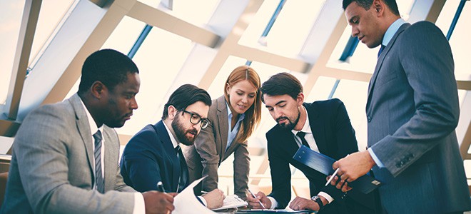 A group of office workers discussing work together to illustrate the reasons for rising demand for translation services in singapore