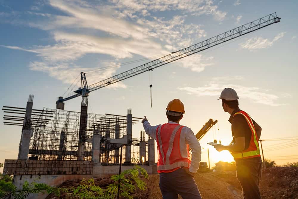 Workers observing a construction site illustrating the importance of technical translation services for construction workers communication