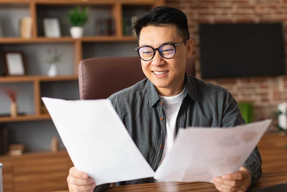 A smiling man vetting a copy illustrating the importance of vetting services