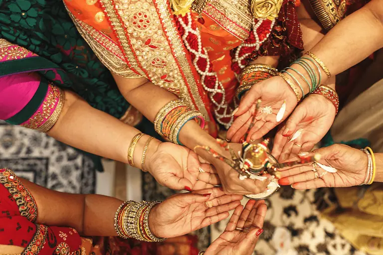 Many hands holding a candle of light illustrating the importance of tamil translation services